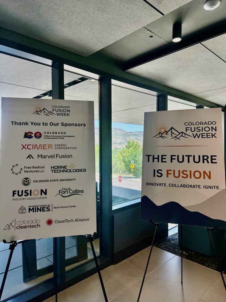 Banners at an indoor event reading 'Colorado Fusion Week' with sponsor logos and the slogan 'The Future is Fusion'.